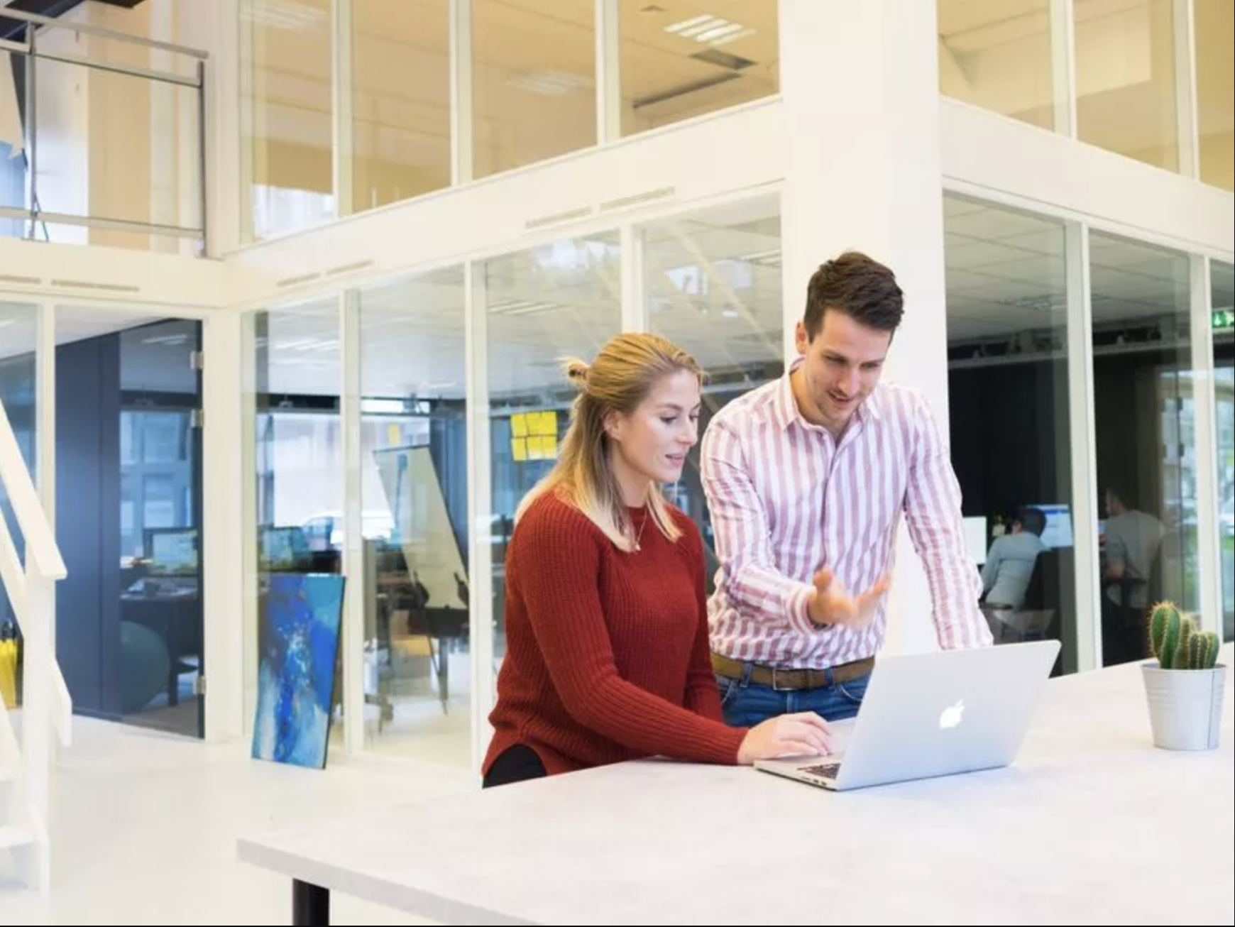 This picture shows a woman and a man standing in a modern office.